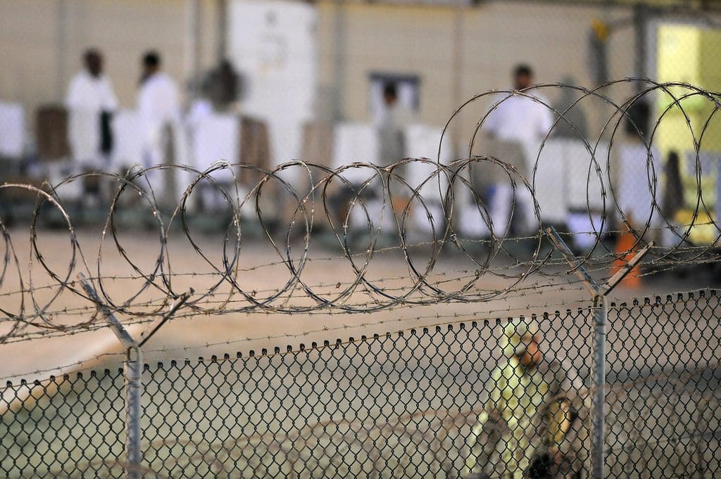 GUANTANAMO BAY, Cuba  A Navy guard assigned to Joint Task Force Guantanamos Navy Expeditionary Guard Battalion patrols Camp Deltas recreation yard during the early morning of July 7, 2010. Camp Delta is a communal living facility and the detainees housed at Camp Delta are able to use the recreation yard for up to 20 hours a day. The Sailors of the NEGB provide a portion of the guard force inside Joint Task Force Guantanamos detention facilities. JTF Guantanamo provides safe, humane, legal and transparent care and custody of detainees, including those convicted by military commission and those ordered released by a court. The JTF conducts intelligence collection, analysis and dissemination for the protection of detainees and personnel working in JTF Guantanamo facilities and in support of the War on Terror. JTF Guantanamo provides support to the Office of Military Commissions, to law enforcement and to war crimes investigations. The JTF conducts planning for and, on order, responds to Caribbean mass migration operations. (JTF Guantanamo photo by U.S. Air Force Tech. Sgt. Michael R. Holzworth) UNCLASSIFIED  Cleared for public release. For additional information contact JTF Guantanamo PAO 011-5399-3589; DSN 660-3589 www.jtfgtmo.southcom.mil