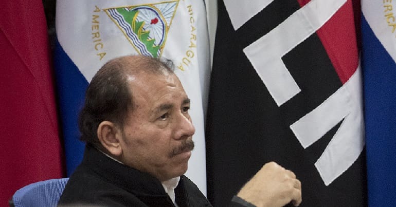 President Daniel Ortega in front of Nicaragua and FSLN flags