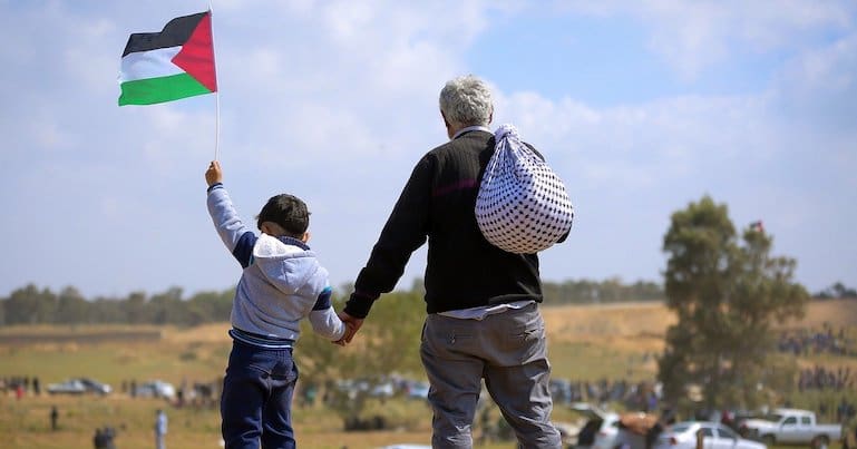 A boy holding hands with a man in Gaza