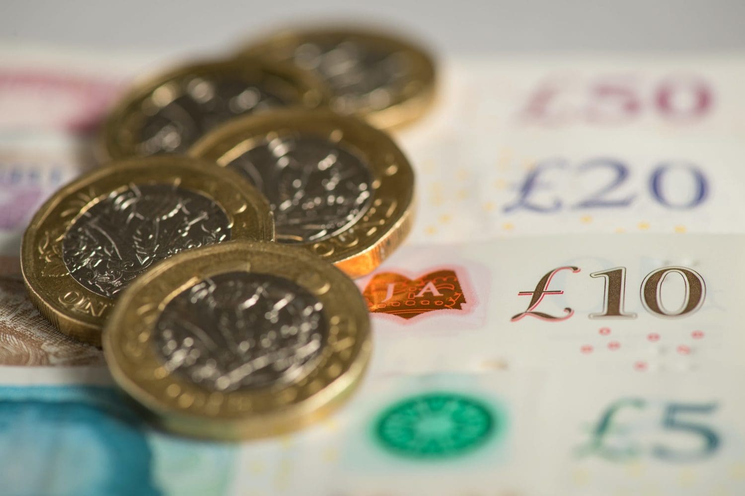 Pound coins on top of £20 notes