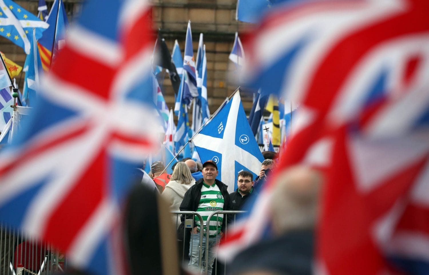 Scots with Saltires looking at a couple of Union Flags in the distance