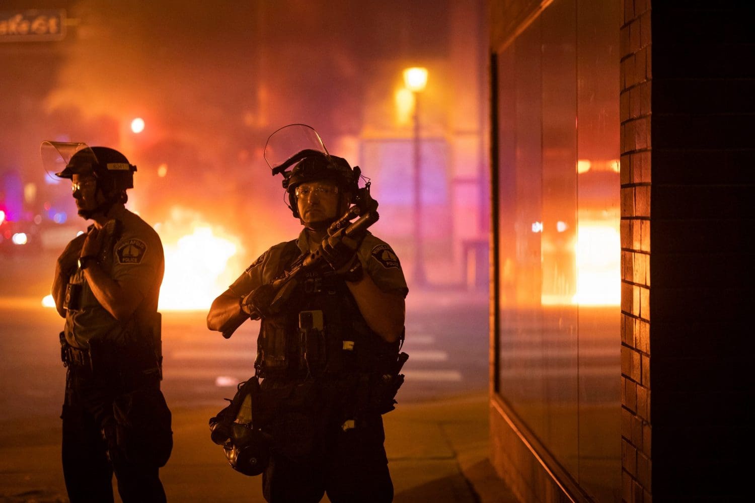 Riot police in front of a flaming fire