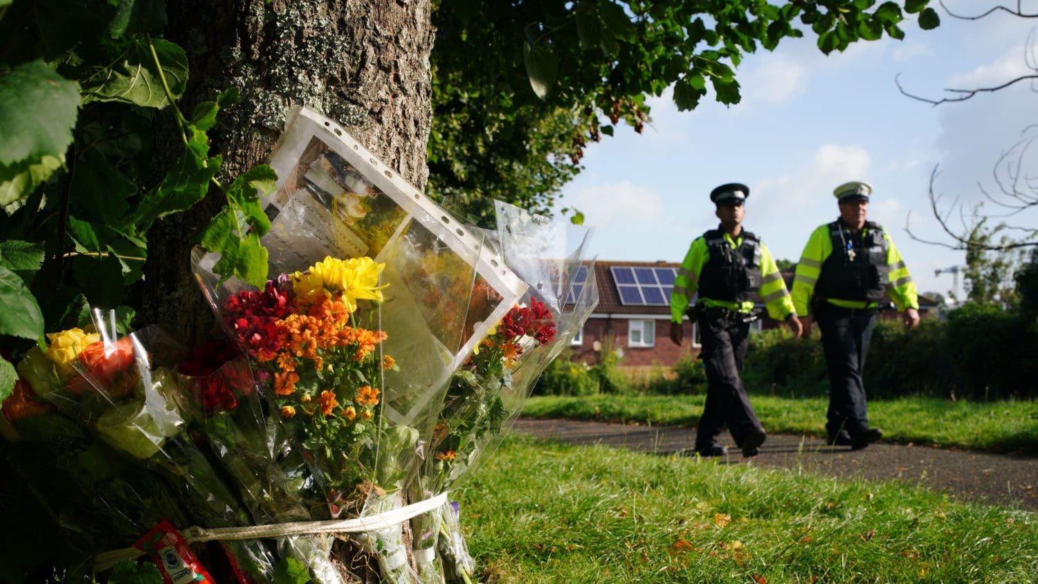 Police officers and flowers left in memory of the victims of the shooting