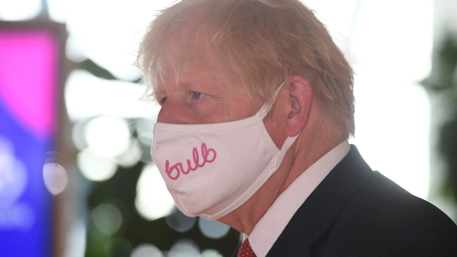 Boris Johnson wearing a face mask with the bulb logo on it