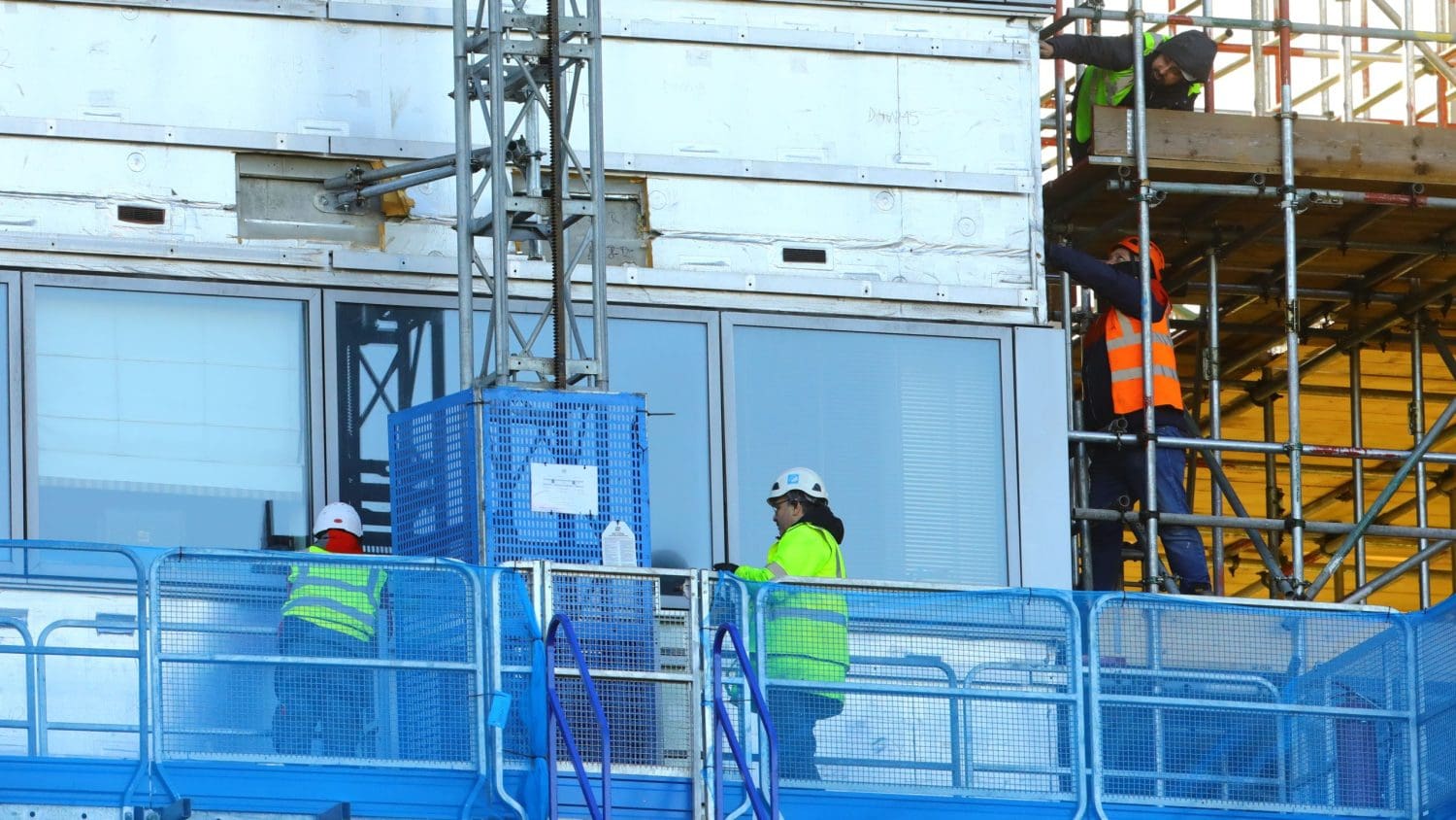 Workers on the side of a building