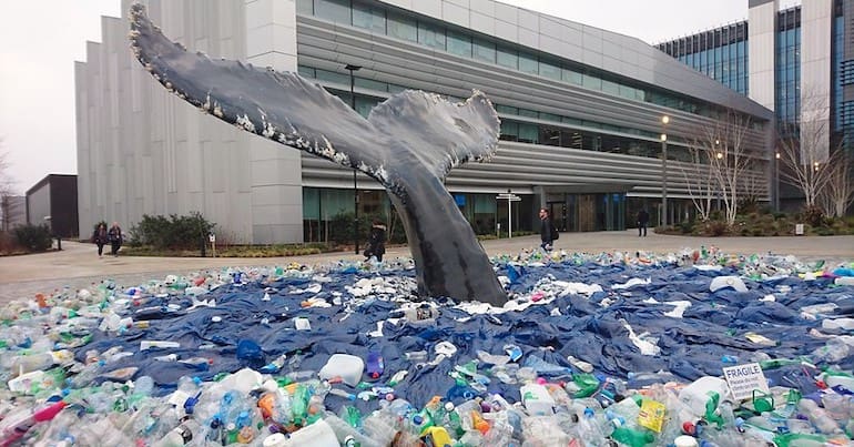 Ocean artwork with whale tail emerging from ocean made up of plastic waste