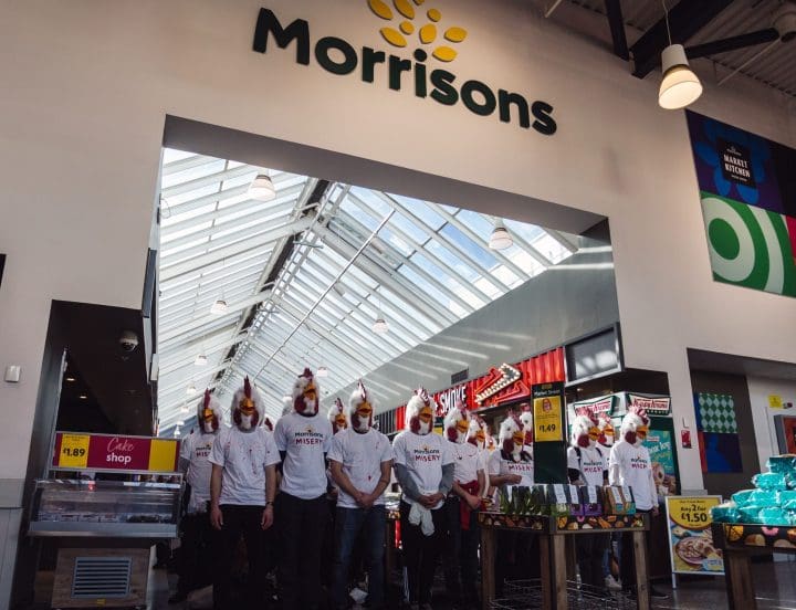 People dressed in chicken costumes against a Morrisons sign 