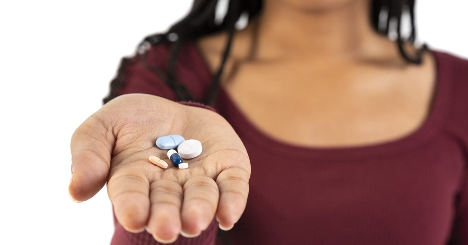 A black woman holding tablets in her hand representing mental health