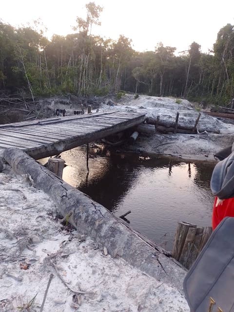 Unpaved illegal side road and improvised bridge, branching off BR-319