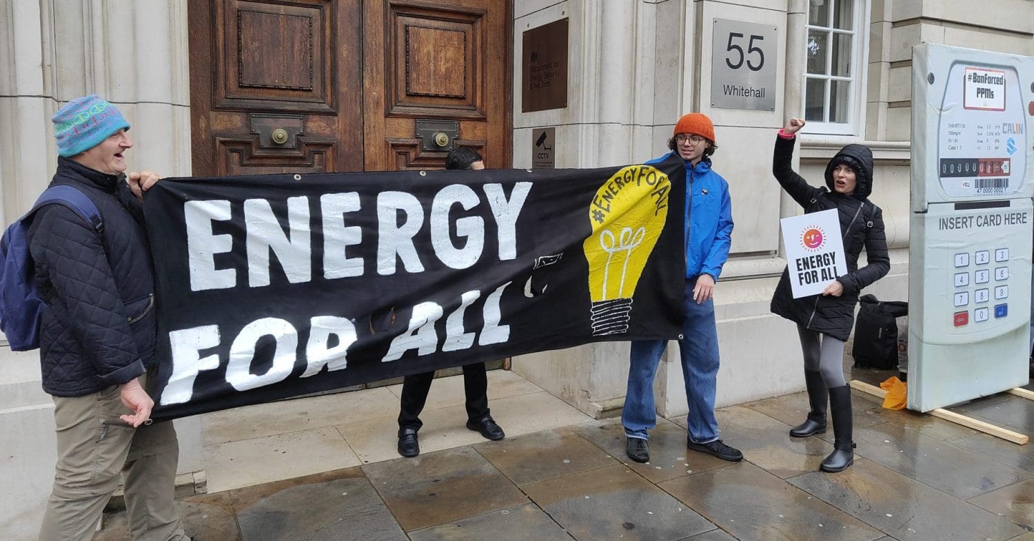 Fuel Poverty Action protesting over prepayment meters outside the department for energy security with banners that read "energy for all"