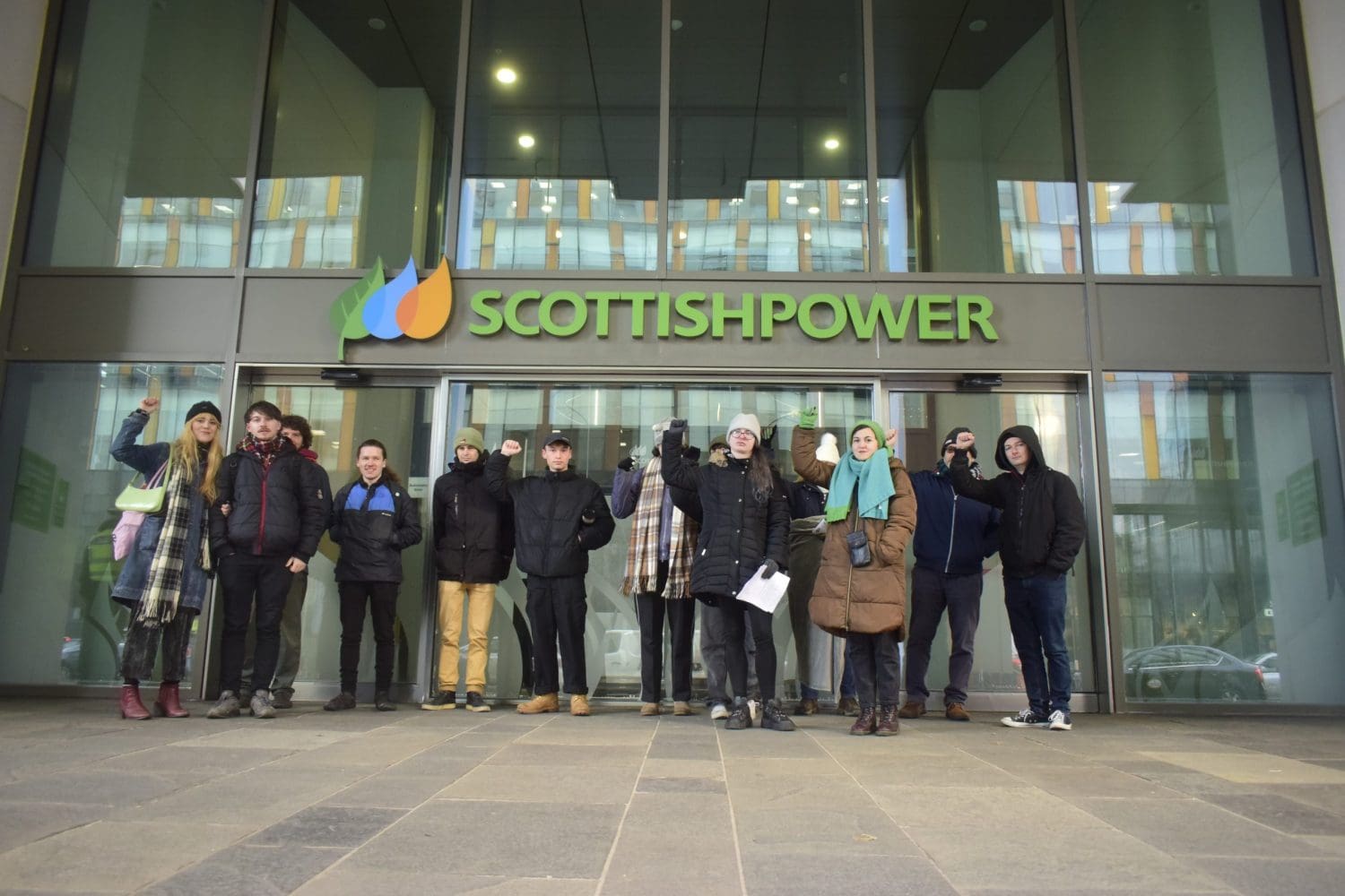 People lined up with their fists in the air outside Scottish Power's head office