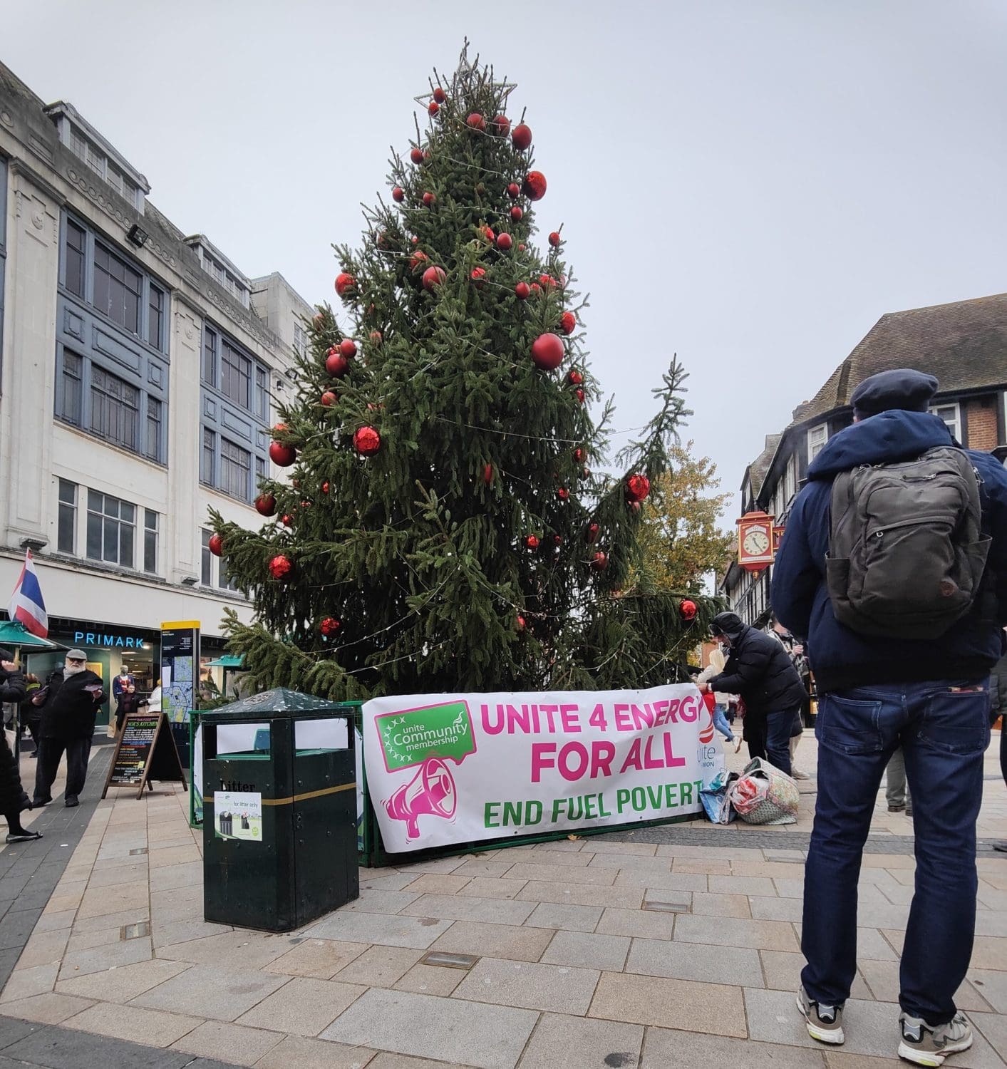 A banner reading "unite 4 energy for all" attached to the bottom of a Christmas tree 