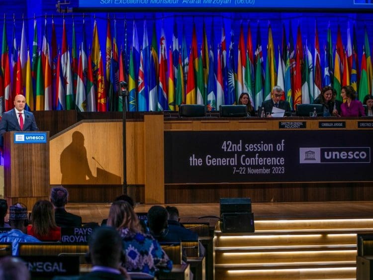 Speaker at the podium at a UNESCO World Heritage Day meeting in 2023.