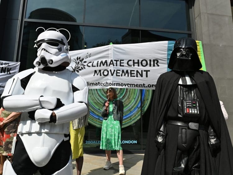 Climate Choir protesters stand alongside Darth Vader and a Storm Trooper outside Standard Chartered's AGM.