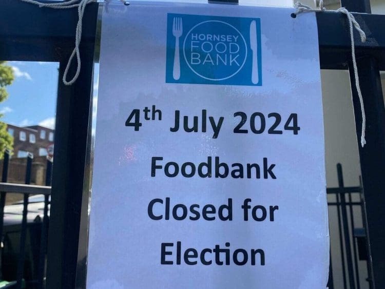 Sign attached to railings outside a church, which reads: Hornsey Food Bank - 4th July 2024 foodbank closed for election.