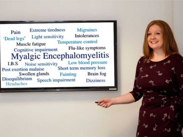 Sally Callow with a screen describing ME/CFS symptoms