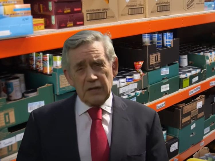 Former Labour leader Gordon Brown with foodbank shelves behind him Guardian