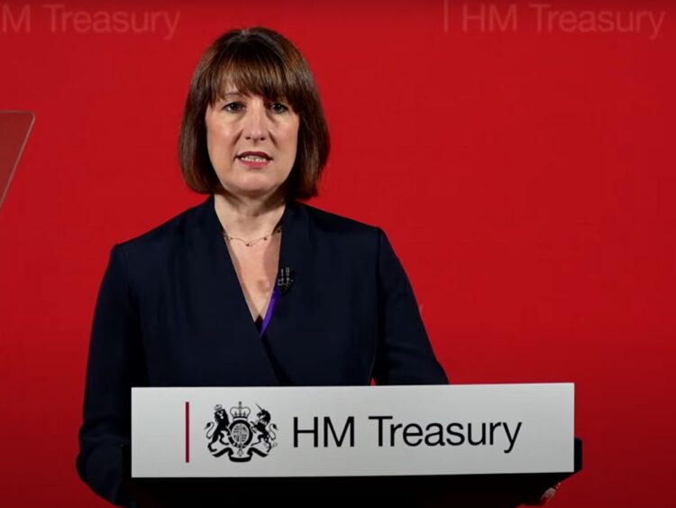 Chancellor Rachel Reeves standing at a HM Treasury podium winter fuel payment