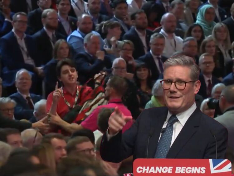 Keir Starmer pointing from his podium which reads: "Change begins" as a protester in a crowd speaks out, with security guards preparing to remove him Labour Palestine