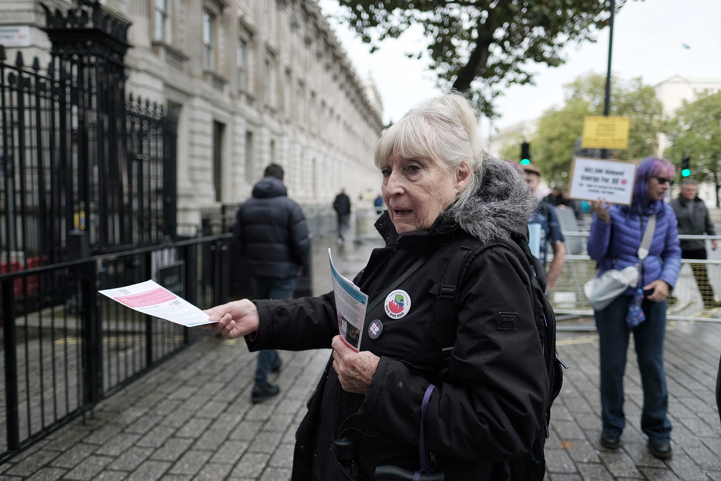 Campaigner hands out and information postcard to a member of the public. 