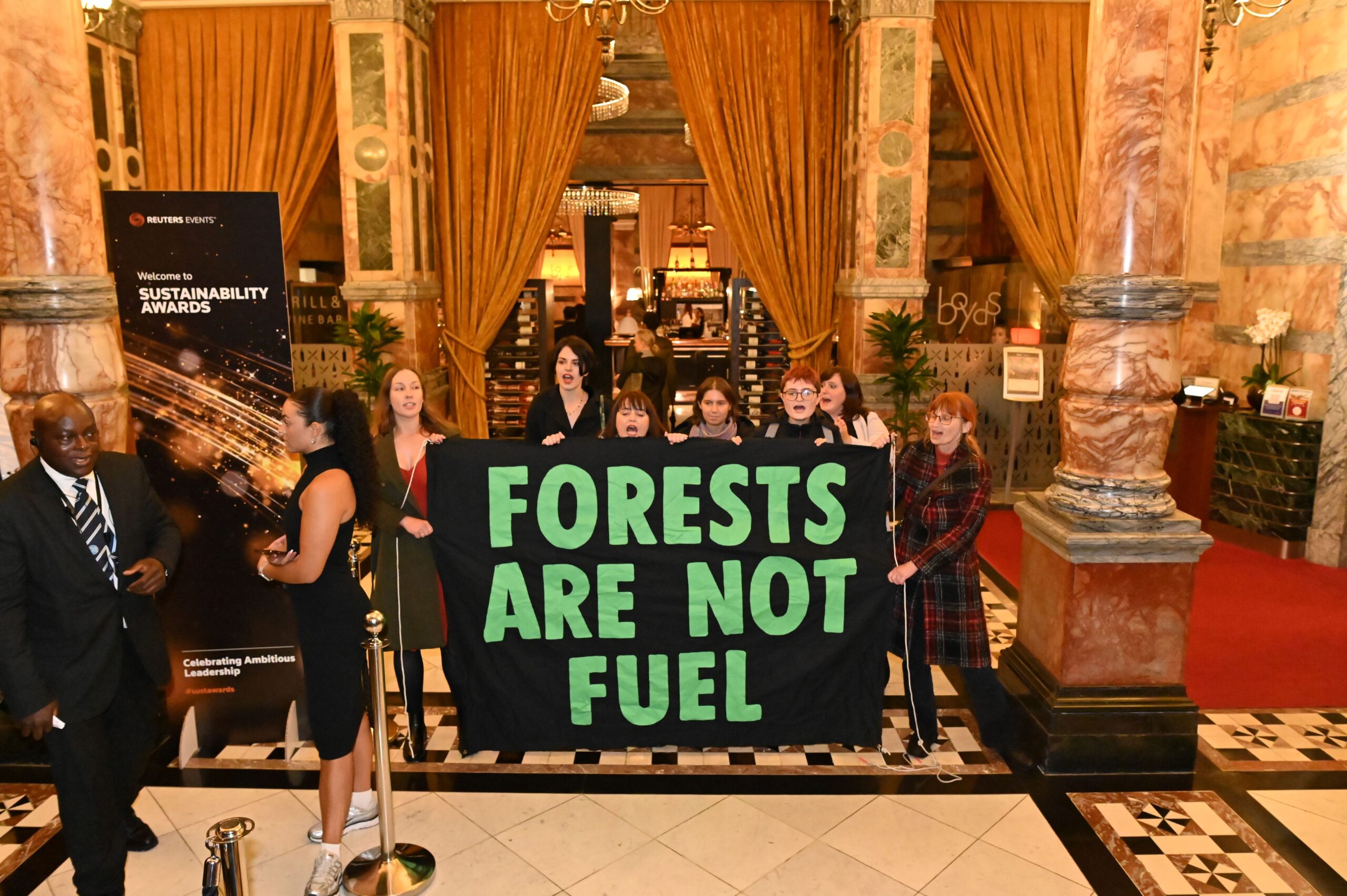 Protesters hold a banner in the foyer which reads: "Forests are not fuel". 