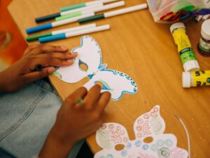 Colouring in a moth mask. 