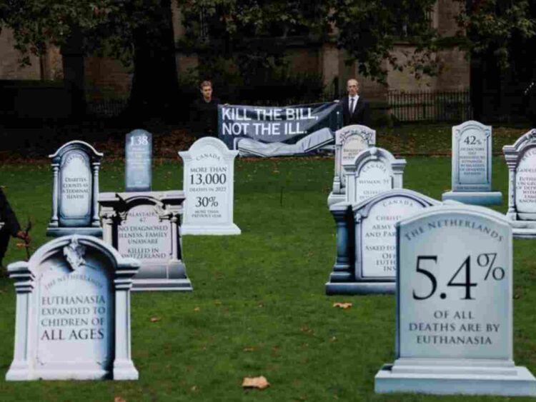 assisted dying a mock graveyard with tombstones carved with figures against assisted dying